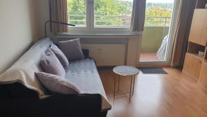 een woonkamer met een bank en een groot raam bij Single-Apartment Essen in Essen