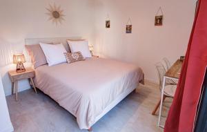 ein Schlafzimmer mit einem großen weißen Bett und einem Tisch in der Unterkunft Chambres d'hôtes du Val d'Asson in Montaigu-Vendée