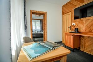 a room with a table with a television and a desk at My Tatra Residence in Zakopane