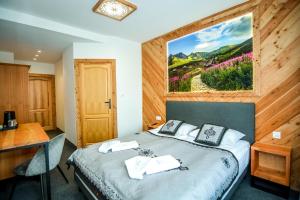 a bedroom with a bed with a painting on the wall at My Tatra Residence in Zakopane