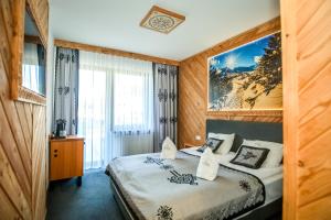 a hotel room with a bed and a large window at My Tatra Residence in Zakopane