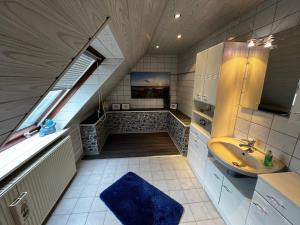 een badkamer op zolder met een wastafel en een trap bij Ferienhaus Marlies und Piet in Bremerhaven
