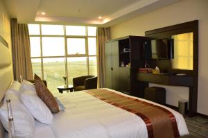 a hotel room with a bed and a large window at فندق جولدن أرمادا جيزان Golden Armada Hotel in Jazan