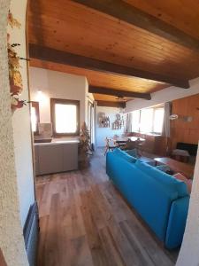 a living room with a blue couch and a table at Ventoux 24 in Enchastrayes