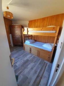 a bedroom with two bunk beds and a wooden floor at Ventoux 24 in Enchastrayes
