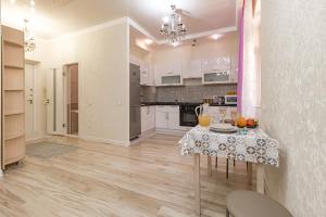 a kitchen with a table and a dining room at Expo Promenade Уютная квартира возле Expo in Prigorodnyy