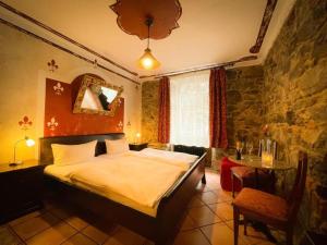 a bedroom with a bed and a table and a chair at Black Forest Hotel Todtnau in Todtnau