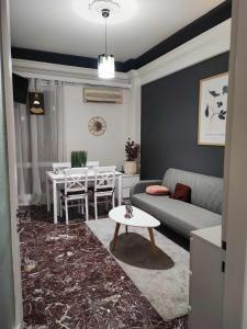 a living room with a couch and a table at OLGAS SQUARE APARTMENT CKBSM in Patra