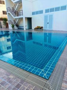 a swimming pool in the middle of a house at Mayflower Grande Suite Hotel in Phitsanulok