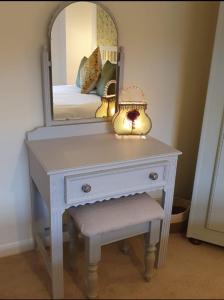 a dressing table with a mirror and a lamp on it at Station House in St Austell