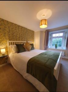 a bedroom with a large bed and a window at Station House in St Austell