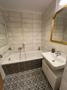 a bathroom with a bath tub and a sink at Gästewohnung Eberswalde in Eberswalde