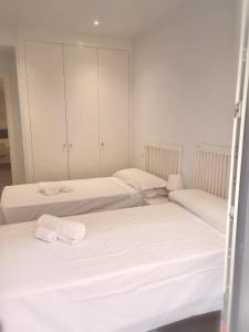 - 3 lits dans une chambre aux murs blancs dans l'établissement El Comienzo, à Tolède