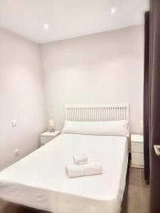 - un lit blanc avec 2 serviettes blanches dans l'établissement El Comienzo, à Tolède