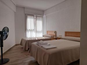 Habitación de hotel con 2 camas y ventilador en Pension Iruna en Santurce