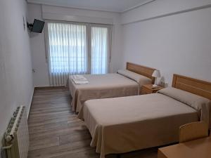A bed or beds in a room at Pension Iruna