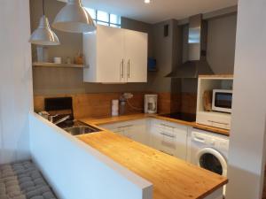 uma cozinha com armários brancos e uma máquina de lavar roupa em Joli T2 au coeur de Praloup 1600 em Uvernet