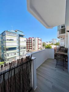 een balkon met uitzicht op een stad met gebouwen bij Apartamento muito central - 300 metros da Praia in Costa da Caparica