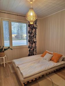 1 cama grande en un dormitorio con lámpara de araña en Private Villa, 127m2, 3 br, sauna, fast wifi en Rovaniemi