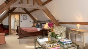 a living room with a bed and a table with books at Beaufort Farmhouse in Grosmont