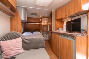 Cette caravane comprend un salon avec un canapé et une télévision. dans l'établissement Galo Preto - Amazing breakfast Sintra - View and Silence, à Sintra