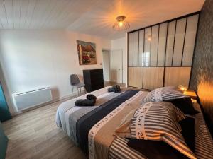 a bedroom with a large bed and a chair at Le Phare des Baleines in La Flotte