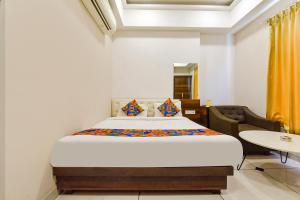 a bedroom with a bed in a room with a table at FabHotel Prime Kingfisher in Udaipur