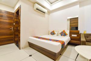 a bedroom with a bed and a table and a door at FabHotel Prime Kingfisher in Udaipur