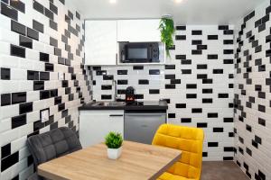 uma pequena cozinha com uma mesa e cadeiras amarelas em Nets Inn Apartments - Buttes Chaumont D em Paris