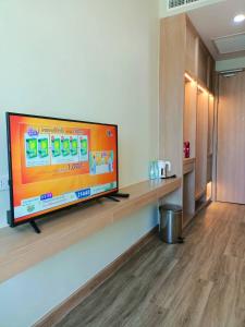 uma grande televisão de ecrã plano numa parede num quarto em Mayflower Grande Suite Hotel em Phitsanulok