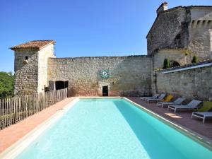 una piscina frente a un edificio en Castle 12th century with private pool close to Agen, en Saint-Caprais-de-Lerm