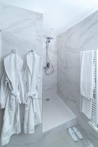 La salle de bains blanche est pourvue d'une douche et de serviettes blanches. dans l'établissement FINESTATE Coliving Champs-Elysées, à Paris