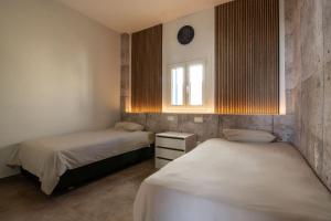 duas camas num quarto com uma janela e duas camas sidx sidx em Villa Alex em La Isleta del Moro