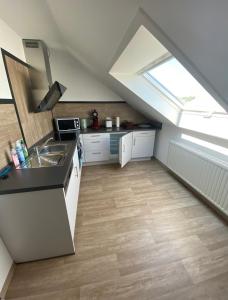 SchiffweilerにあるFerienwohnung Am Rathausbergの屋根裏のキッチン(シンク、窓付) +7枚の写真