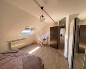 ein Schlafzimmer mit einem Bett und einem Tisch in einem Zimmer in der Unterkunft Ferienwohnung Am Rathausberg in Schiffweiler