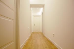 an empty hallway with a white door and a wooden floor at Hotel Ciao in Rome