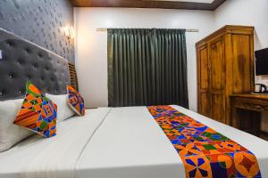 um quarto com uma cama com um edredão colorido em FabHotel Bay Boutique By Foxtale em Marmagao