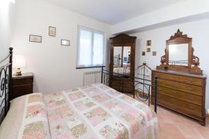 1 dormitorio con cama, tocador y espejo en Casa Elena, en Moneglia