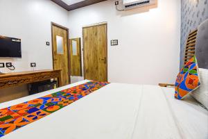 um quarto com uma cama com um cobertor colorido em FabHotel Bay Boutique By Foxtale em Marmagao