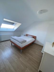 a bedroom with a bed and a skylight at Ferienwohnung Am Rathausberg in Schiffweiler