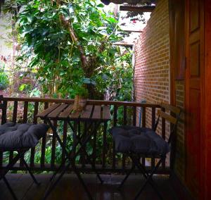 拜縣的住宿－Pai Kiniman Resort，门廊上的一张木桌和两把椅子