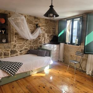 a bedroom with a bed and a stone wall at El Abuelo Angel in Ribadavia