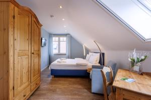 ein Schlafzimmer mit einem Bett und einem Tisch in einem Zimmer in der Unterkunft Gästehaus Drostenhof in Rees