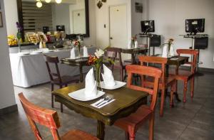 un restaurante con mesas de madera y sillas con flores. en Hotel Sunqu, en Lima