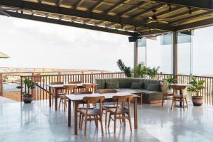 a patio with tables and chairs and a couch at Grün Resort Uluwatu in Uluwatu