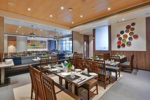 une salle à manger avec des tables et des chaises ainsi qu'un restaurant dans l'établissement Rakabi The Fern, Igatpuri, à Igatpuri