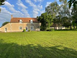 a large grass field in front of a house at Maison de Campagne avec Piscine, Vallée de la Loire in Sarcé