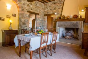 a dining room with a table and a fireplace at Villa Orizzonte - Homelike Villas in Todi