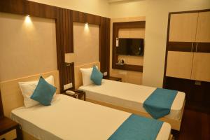a hotel room with two beds with blue pillows at Hotel Avenue Plaza, Serampore - N S Avenue 