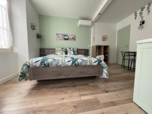 1 dormitorio con 1 cama y suelo de madera en Studio de la Poterie, en Vermenton
